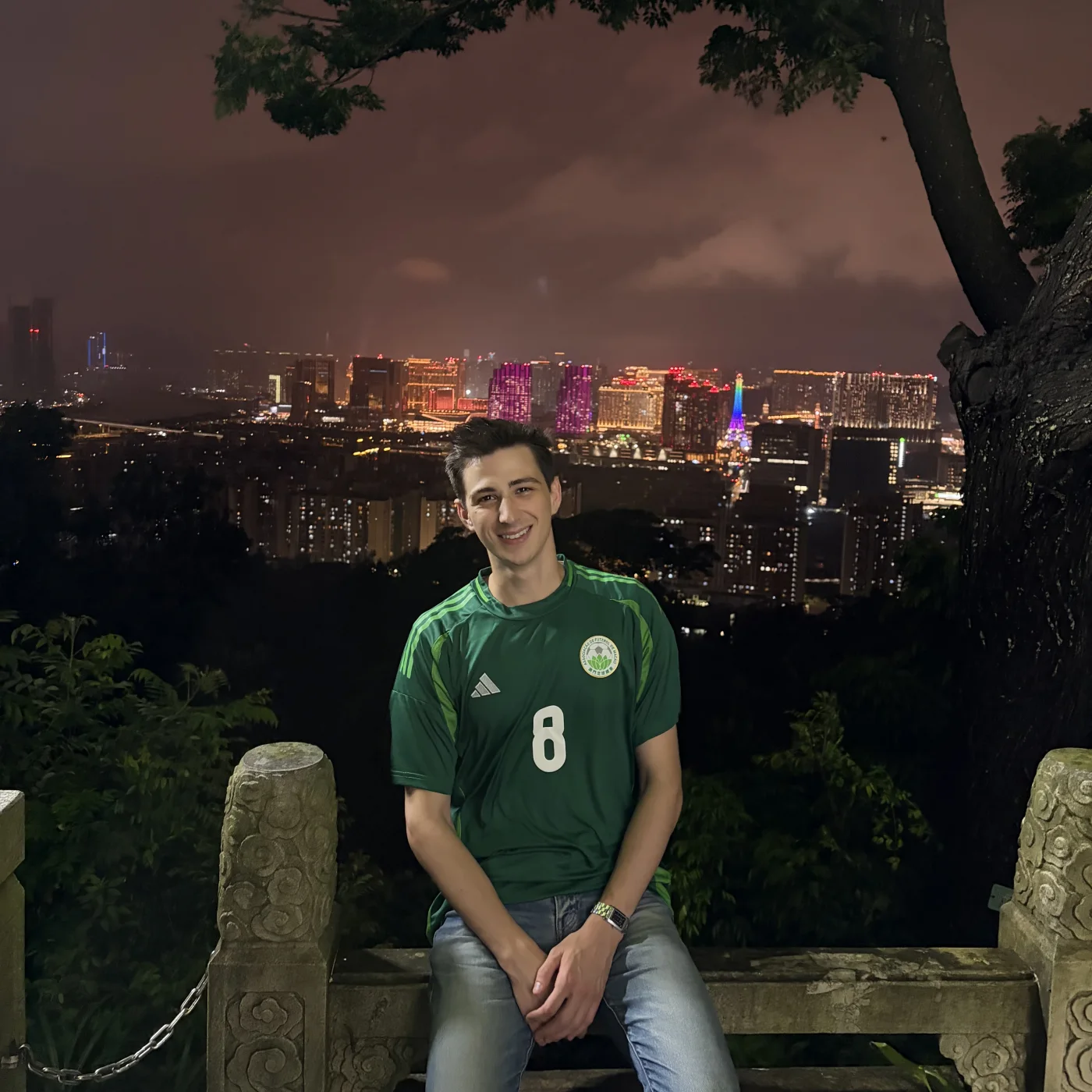 Mana Azizsoltani wearing his custom Macau national football team jersey above the Macau skyline