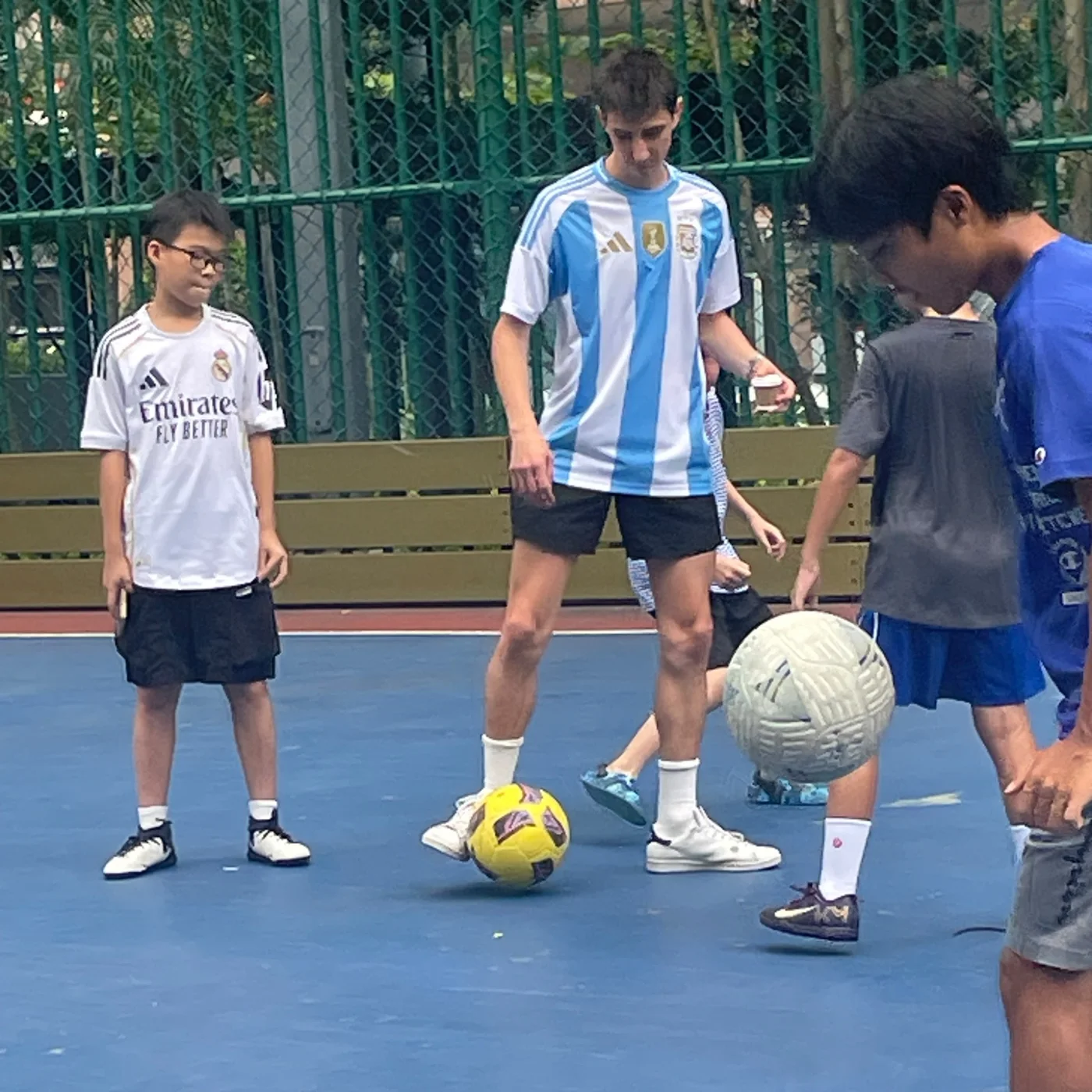 Mana Azizsoltani playing soccer with children at Taipa Central Park in Macau