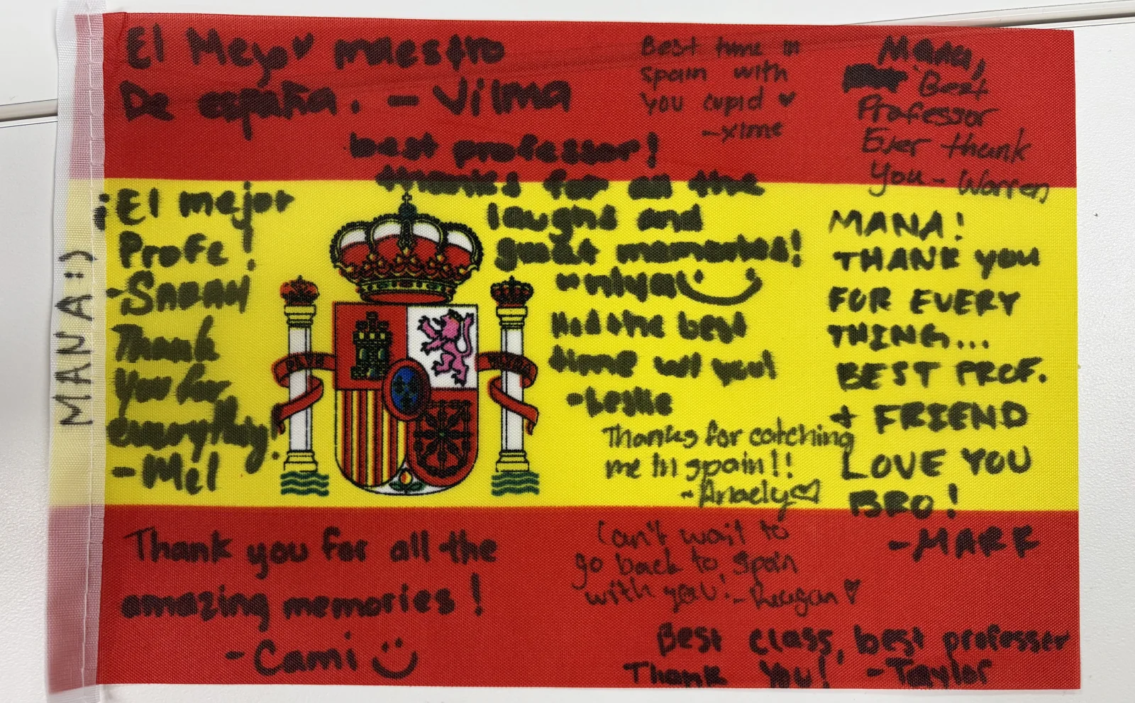 Mana Azizsoltani holding a small Spanish flag signed by the FAB 333 study-abroad students